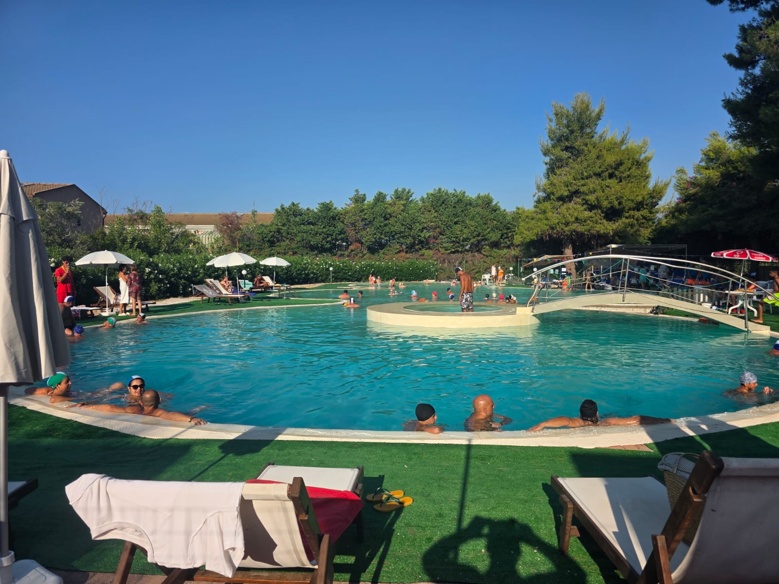 Piscina con solarium, lettini e ombrelloni a disposizione degli ospiti di Casa Vacanza Pinto