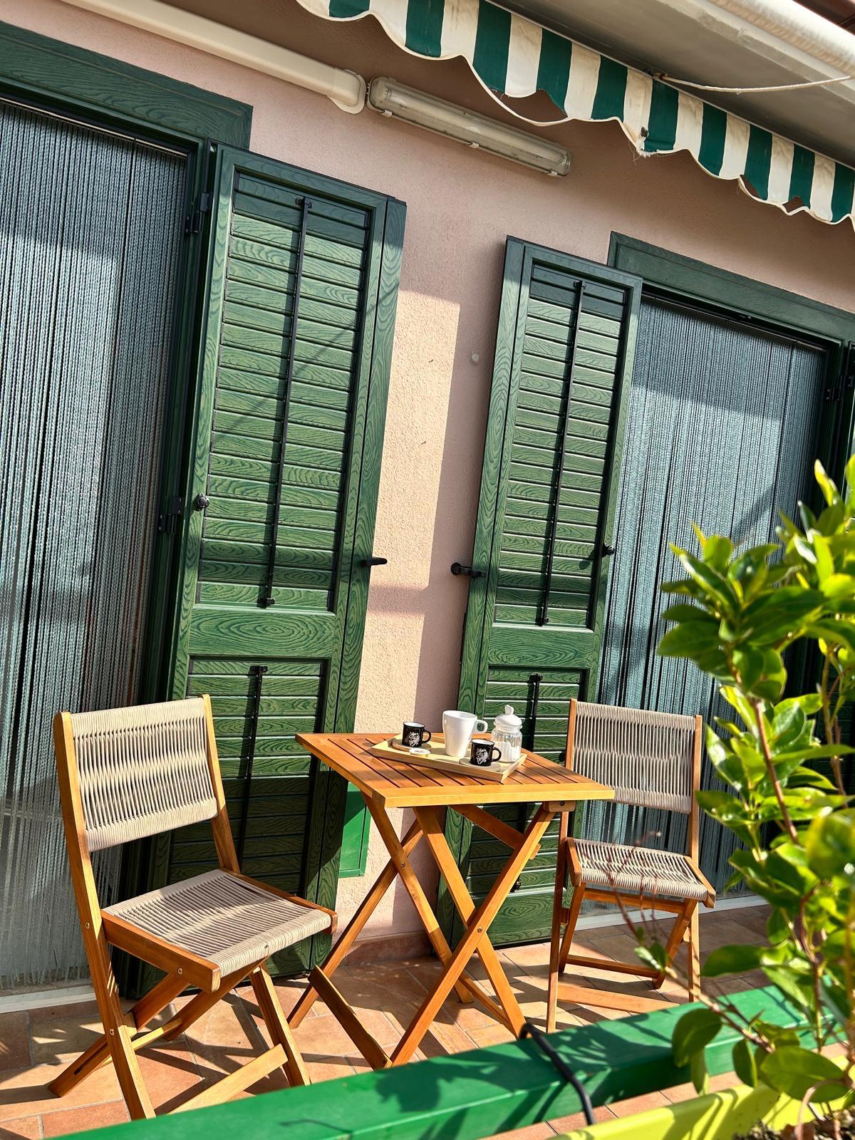 Veranda con tavolino e persiane verdi
